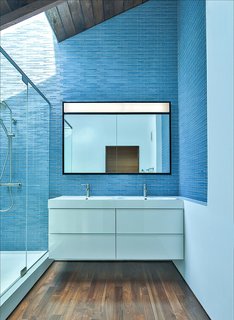 Blue tiles reflect daylight on the dark wooden floors and ceiling frame. Martin Fenlon Architecture is a Los Angeles-based firm that's committed to seeking sustainable architecture in innovative spaces.