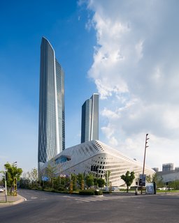 The Culture and Conference Centre masterplan expresses the continuity, fluidity and connectivity between the urban environment of Hexi New Town, the agricultural farmland along the Yangtze river and the rural landscapes of Jiangxinzhou Island. The complex consists of two towers rising from a five-story, mixed-use podium. The taller of the towers rises 68 floors and contains a 5-star hotel and office floors, while the 59-story tower houses an additional hotel to accommodate visitors to the conference center below.