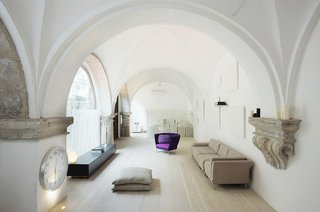 In a renovation by Estudio VilaBlanch in a historic neighborhood in Barcelona, cloisters dating from the 1600s were converted into a residence. Hand-carved stone features were left exposed and utilized as shelves, including horizontal belt courses, columns, and imposts for the vaults.