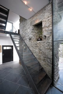 Separating the interior of the home from the exterior courtyard are exposed load-bearing limestone walls.
