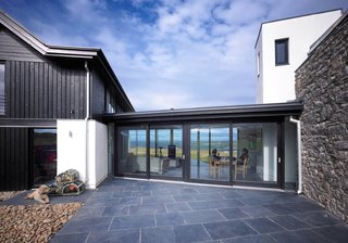The glazed living room links the two distinct parts of the house, creating an H shape in plan.