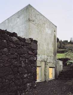 The concrete structure was designed to fit within the existing dark volcanic rock walls.