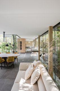 A Portuguese Glass House Uses Surrounding Foliage as a Privacy Screen - Photo 8 of 15 - A neutral palette for furniture keeps the interior feeling light and sun-drenched.