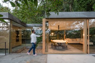 A Portuguese Glass House Uses Surrounding Foliage as a Privacy Screen - Photo 11 of 15 - The home has sliding doors with thick wood frames.