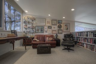 A sitting room/library on the second-floor mezzanine level gives the sensation of being up in the trees, while still allowing for views down into the living room below.