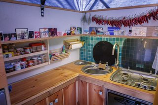 Efficient storage in the kitchen included shelving that double as areas for display of travel memories and photos of family and friends.