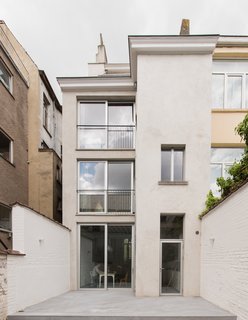 The back facade features large windows to bring in light to the rear rooms and central stairs.