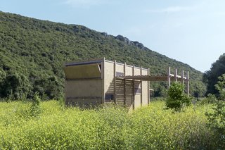 A slatted wood canopy extends from one side of the cabin, providing an increased amount of filtered light.