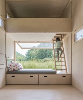 A large cushioned bench at one end of the cabin provides a seating area that looks out onto the landscape beyond.