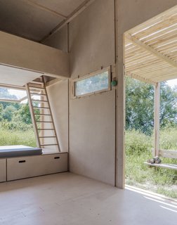 Beds are lofted above the kitchenette and large bench, and are accessible by wooden ladders.