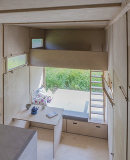 A fold-down table and multi-use bench allow the lower level to also function as a sleeping area.