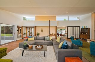 The entry opens out onto the oversized living room, with its high ceilings, floor-to-ceiling glazing, and ample space for multiple seating arrangements.