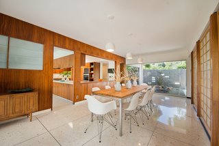 The dining room opens to the kitchen, which features glazing to the yard. The flooring here is the original terrazzo.