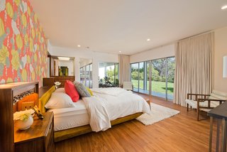 The master bedroom has windows and glass doors that open onto the back yard. The wood floors in this room are new.