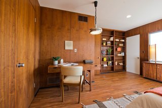 Bedrooms with paneled walls and built-in shelving are unique features to the home.
