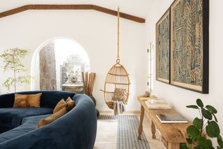 The handmade tile and artwork pick up the blue from the sofa and continue it throughout the space.