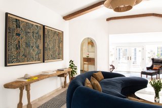 The curvature of the blue sofa is reminiscent of the arched openings leading into the space.