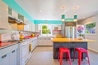 Period-appropriate lighting and bright colors keep the kitchen feeling vintage and yet contemporary.
