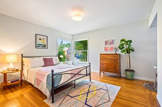 The large master bedroom features hardwood floors and multiple windows.