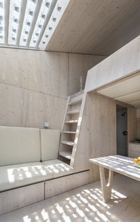 The interior is clad in wood, with a lofted bed at the taller end of the unit.