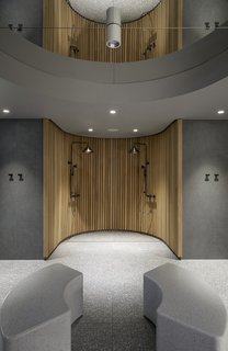 Terrazzo floors and benches are paired with an open wooden shower in the hotel's sauna.