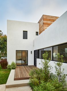 The multiple planes of the facade create a complex form, allowing part of the second floor to hide behind the white plaster cement mass in front.