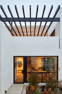 A custom steel and Douglas fir wood trellis provides some relief from the strong California sun, which bounces off the white walls. The trellis is stained with a custom color.