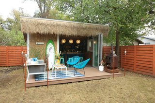 Made from a customized DIY version of an off-the-shelf shed from Tuff Shed, this she shed now houses a bar and opens onto a deck with an outdoor oven and furniture and seating for friends and family.