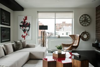 In this apartment, Kesha Franklin of Halden Interiors employs a palette of off-whites paired with a dark floor; moments of red in both the artwork and accent furniture enliven the space.