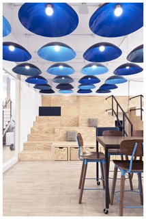 The event space in the startup firm SeatGeek features the "prerequisite" stadium seating that is now found in just about every tech company's offices; however, interior designer Dani Arps distinguishes the space with storage incorporated into the stadium seating and creates a sense of intimacy with a series of low-hung pendants.