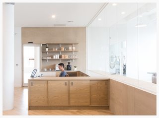 Wood warms up this otherwise all-white office for startup Eligible designed by Dani Arps. Fun, playful details like oversized, exposed white brackets to hold up shelving keep the space from feeling too serious while still being on-brand and design-forward.
