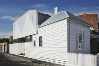 As an addition to a listed home in Melbourne, the local preservation regulations required the alteration be distinct from the historic home. This was done through both form and materiality.
