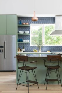 Q&A With an Architect About What it's Like to Design Your Own Home - Photo 4 of 7 - For the kitchen, the architect selected a recycled Fireclay Tile in Slate Blue and paired that with High Park paint from Benjamin Moore. Copper pendants from VITA accent the space. The vent hood is mounted in front of a large window, bringing in natural light and allowing for a view of the herb garden.