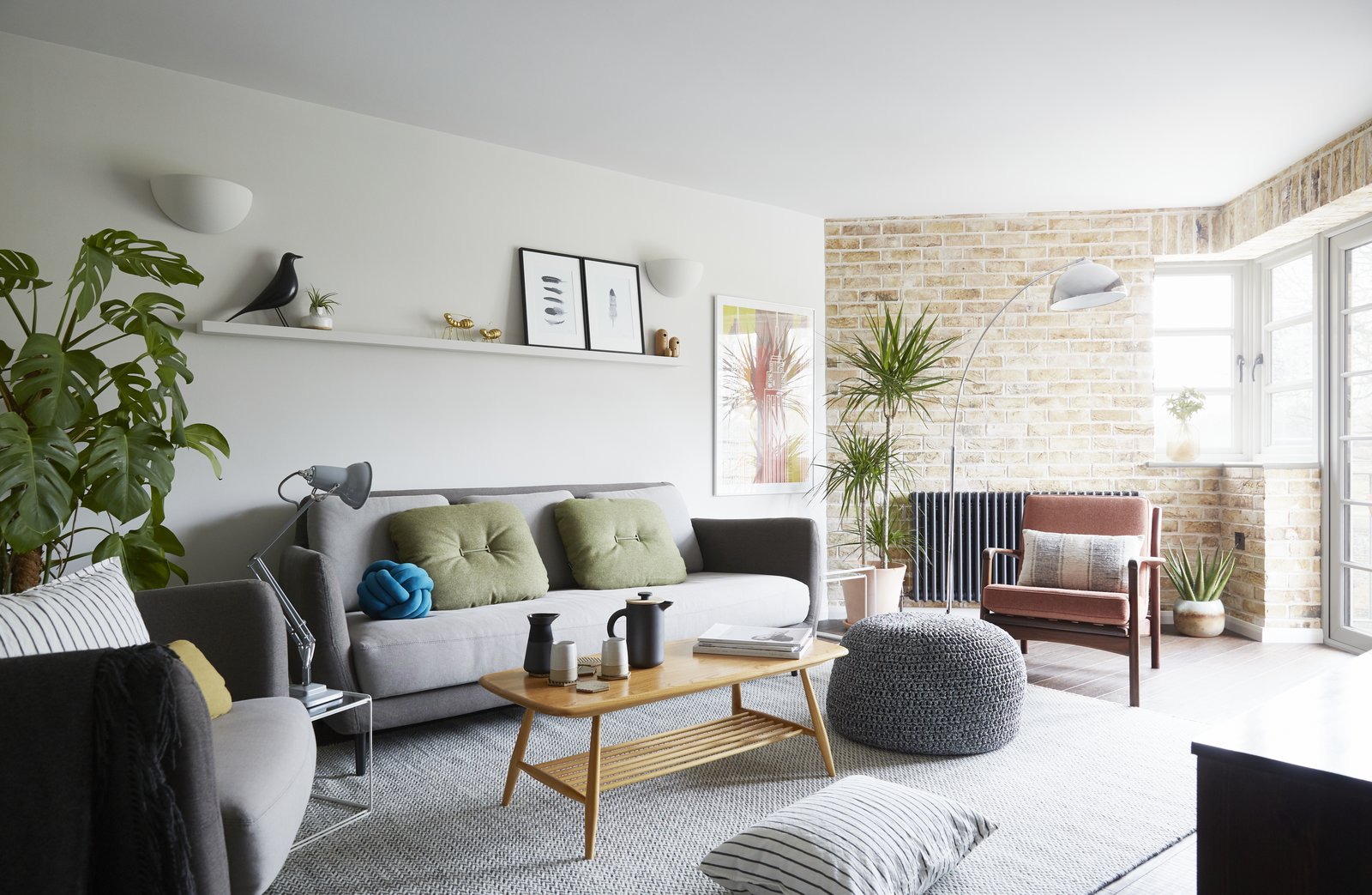 The light-filled living room, with a London stocks brick wall, vintage mid century furnishings and modern Scandi decorative touches.