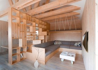 A non-structural ceiling was removed, exposing timber trusses that support a central partition that separates a lounge area on one side, and a workspace on the other.