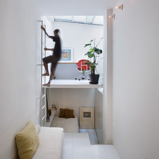 Finished in white, the walls, the floors, and ceiling are contrasted by only splashes of color from sparsely-placed furniture and framed artworks.