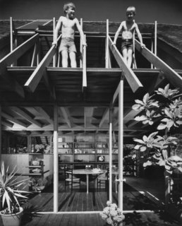 In this photo of the Diamond Street House taken by Julius Shulman, Brock Lyster (left) stands next to his brother on his father's roof truss. 