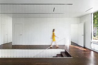 9 Unique Stair Railings - Photo 7 of 9 - The vertically-oriented cable railing in this modern house in Tennessee acts as a screen, providing the illusion of a separation between either side of the staircase while still allowing views across. 
