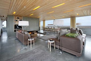 10 Modernist Beach Home Rentals to Escape to This Summer - Photo 6 of 10 - The Dune House is a RIBA Award-winning home created through Living Architecture, a UK-based organization that commissions world-class architects to build holiday rental homes with an overarching goal of expanding the conversation of what constitutes good design. The home, which sits nestled among coastal dunes just steps from the sea, was designed by Jarmund/Vigsnæs Architects as a modern take on English seaside buildings. The roof—constructed to echo the style of local dwellings—features orange steel alloy, which reflects the changing colors of the surrounding landscape. The interior is flanked by banks of windows that overlook the sea and sky for a serene and immersive experience. 