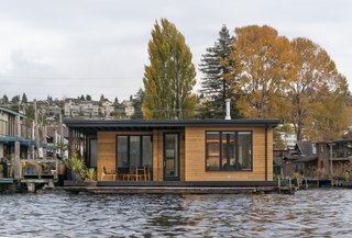 This floating home by Atelier Drome features a wraparound Ipe deck that is accessible from every room. The building is clad in horizontal cedar siding that adds style and warmth to the structure sitting on Lake Union. A cedar slat screen provides privacy from the dock.