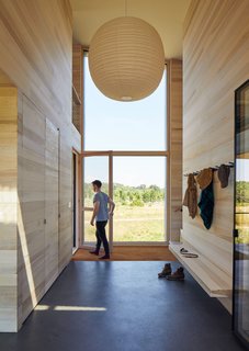 Floor-to-ceiling glazing fills the entryway with light. 