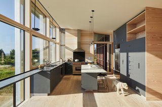 Gray cabinets are paired with granite countertops and a white marble island from Vermont.
