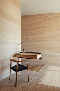 A cantilevered birch and plywood desk appears to effortlessly float in midair. The wood box is attached to the wall with a blackened structural steel angle. "It’s a place to make a phone call, put down keys, plug in the iPhones," says Ryall. "We liked the contrast of the structural steel and the more refined wood box, kind of the like the house, which itself is full of contrasts—rough/smooth, dark/light, open/closed."