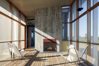 "The fireplace extends the season," says Ryall. "The owners probably use that porch six months out of the year." The design team formed the fireplace’s concrete facade using rough wood boards to give it a rugged texture.