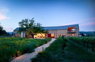 Tasked with creating a multi-use guest pavilion on a relatively small Northern California vineyard lot that could also host sit down dinners for up to 60 people, designers at Anderson Architects started by asking the key questions: "Where should it be within the property?" "How much floor area do we need for a 60 person dinner?" "How much volume do we need for a basketball court?" "We also always tell ourselves to look at the landscape first, let it dominate and lead it through. The building took the form of a large Napa Valley barn."