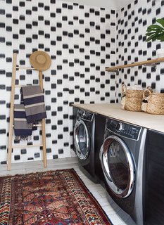 The laundry room features custom wallpaper designed by Samuel.