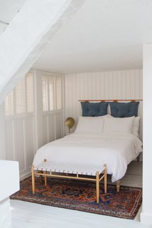 Samuel set up a bed in this den alcove off the living room, to use as a second sleeping spot. The crumbling basket-weave texture was covered with painted wood panelling and the headboard is a DIY.