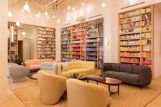 The double-height lending library anchors a corner of the open-plan room. The book collection was curated with Strand Bookstore and includes 2,000 volumes from women authors.