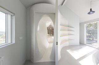 This shows how the freeform wall surfaces are juxtaposed against the more crisp and square geometries of doors and windows.
