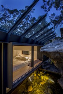 An Arresting Australian Abode by Glenn Murcutt Needs a Buyer - Photo 6 of 8 - The principal bedroom windows embrace the sandstone rock face. A sloped glass roof shields from rain.
